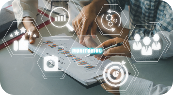 Two people analyze charts and graphs on paper, surrounded by icons representing data and business metrics. The word 'MONITORING' is highlighted in the foreground.